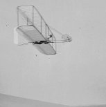 Wilbur Wright pilotuje szybowiec Wright No. 3 w wersji z pojedynczym usterzeniem pionowym. Kitty Hawk, North Carolina 1902. (Źródło: Library of Congress).